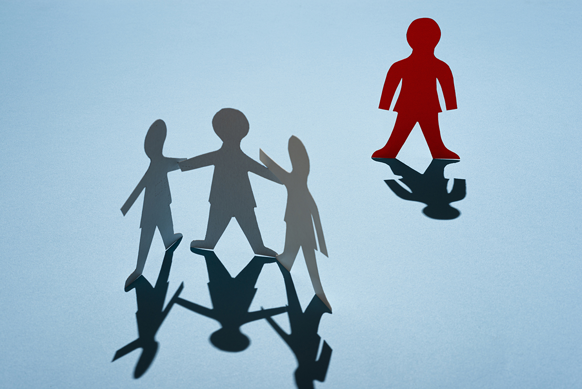 Three paper dolls are grouped together, with one red paper doll standing alone