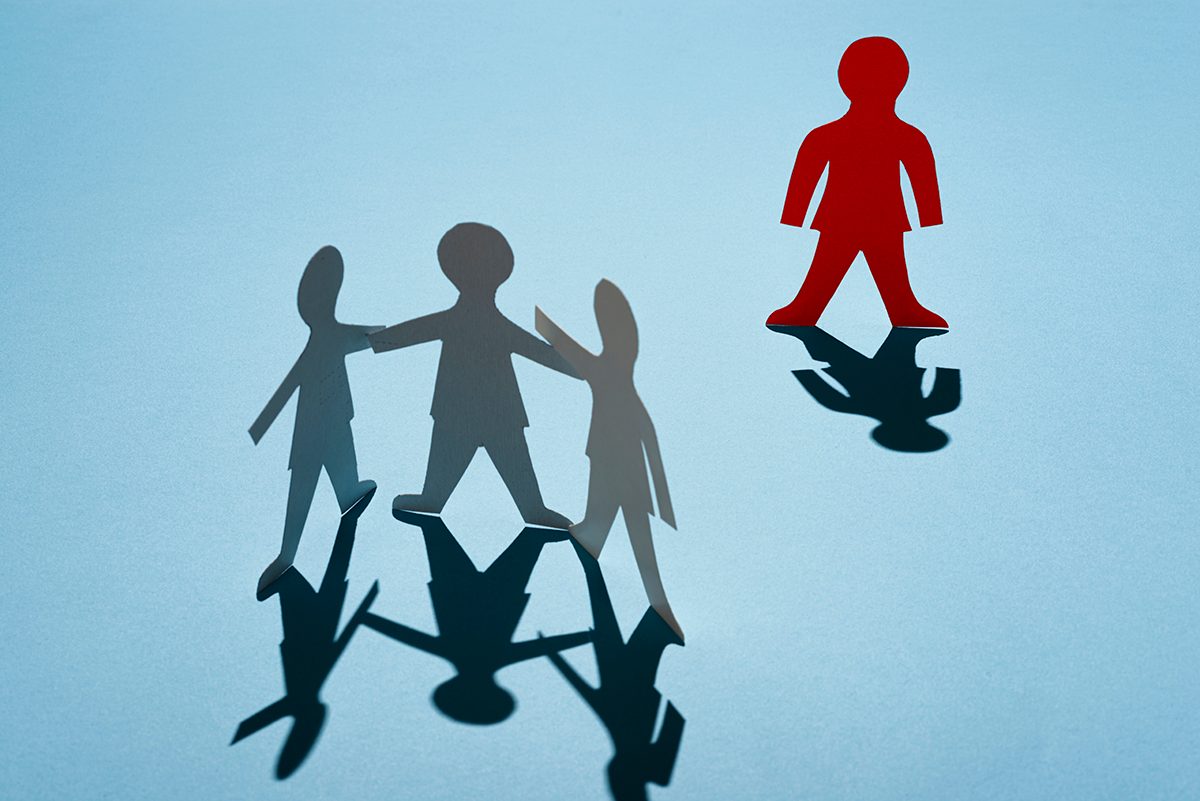 Three paper dolls are grouped together, with one red paper doll standing alone