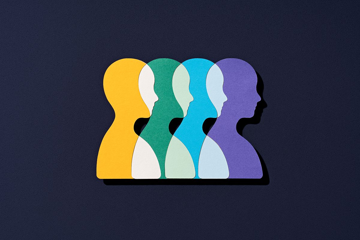 Human heads made from colourful paper overlapping on a black background