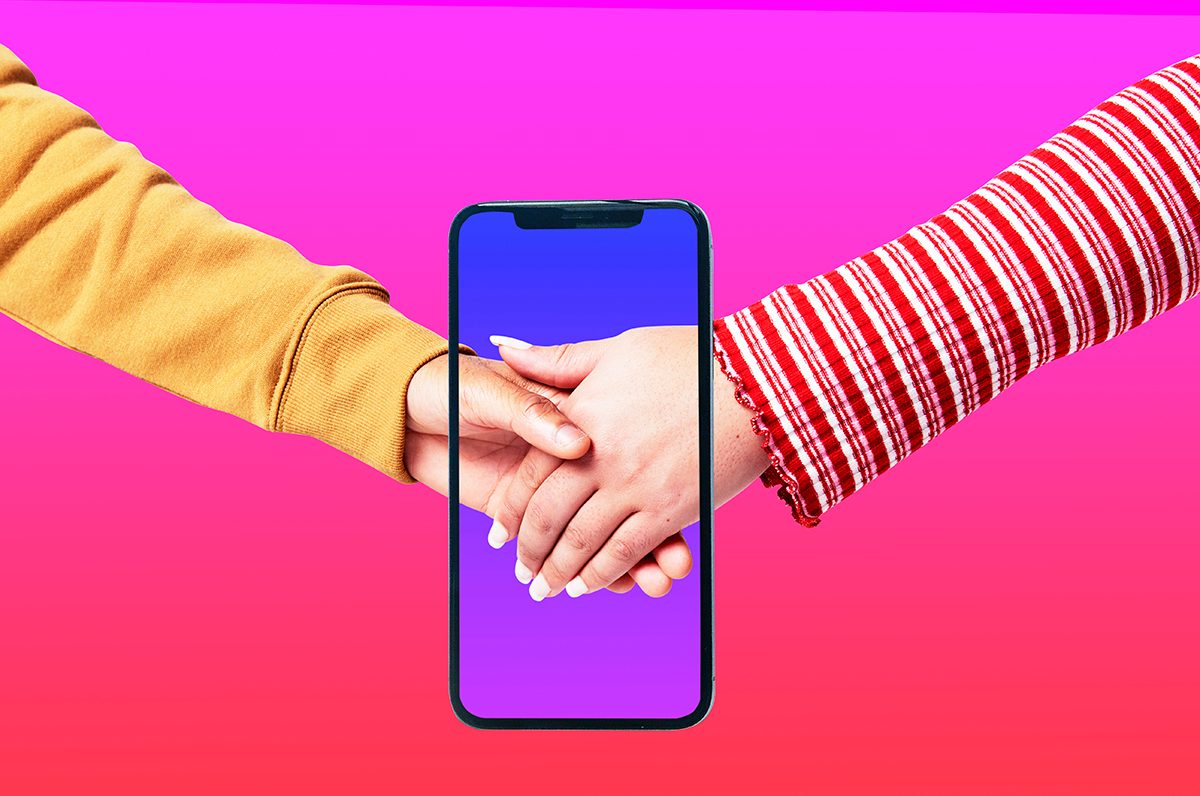 Two hands are clasped together, with a smartphone superimposed in front, set against a bright pink background.