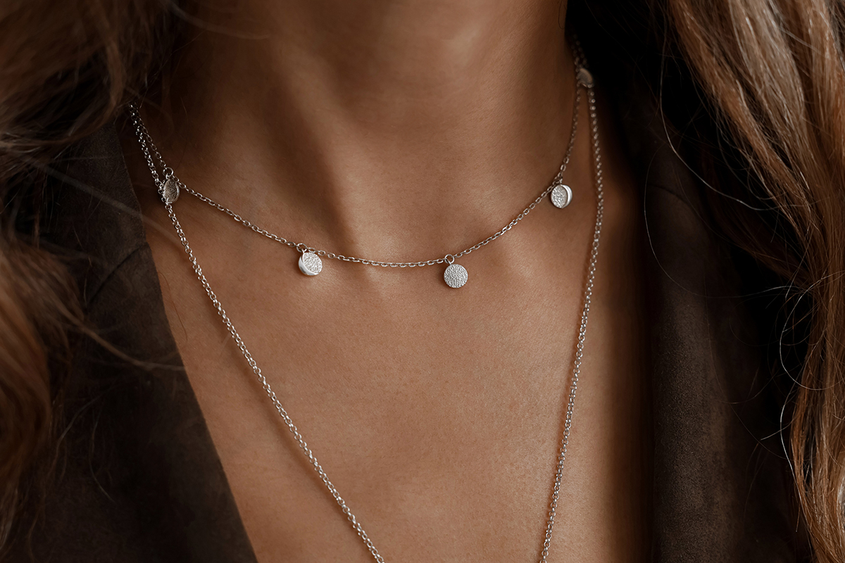 A close up of a woman wearing a silver necklace.