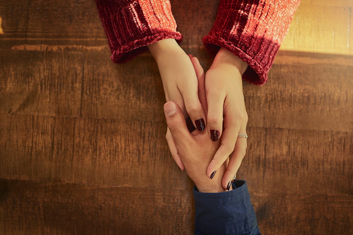 High angle shot of a man and woman holding hands on a table