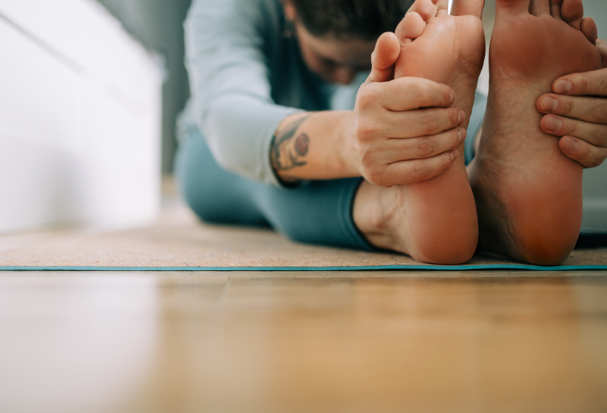 A woman doing a seated forward fold