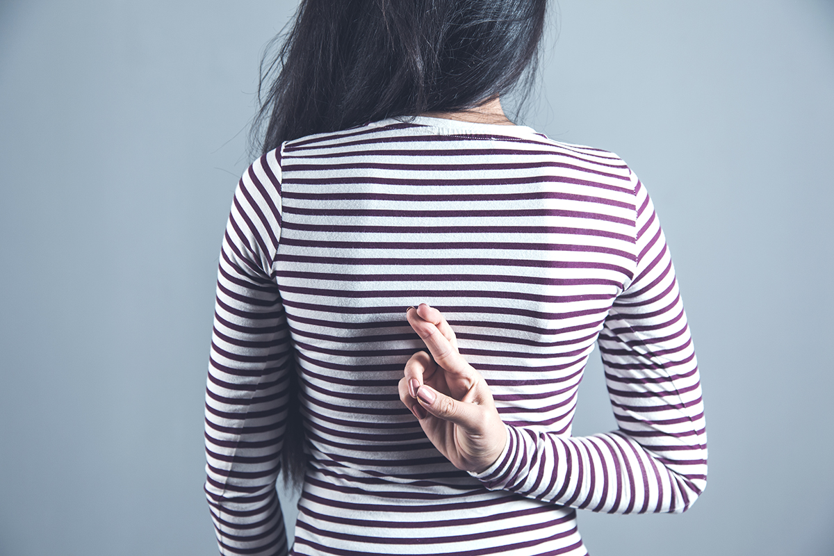 A woman crossing her fingers behind her back