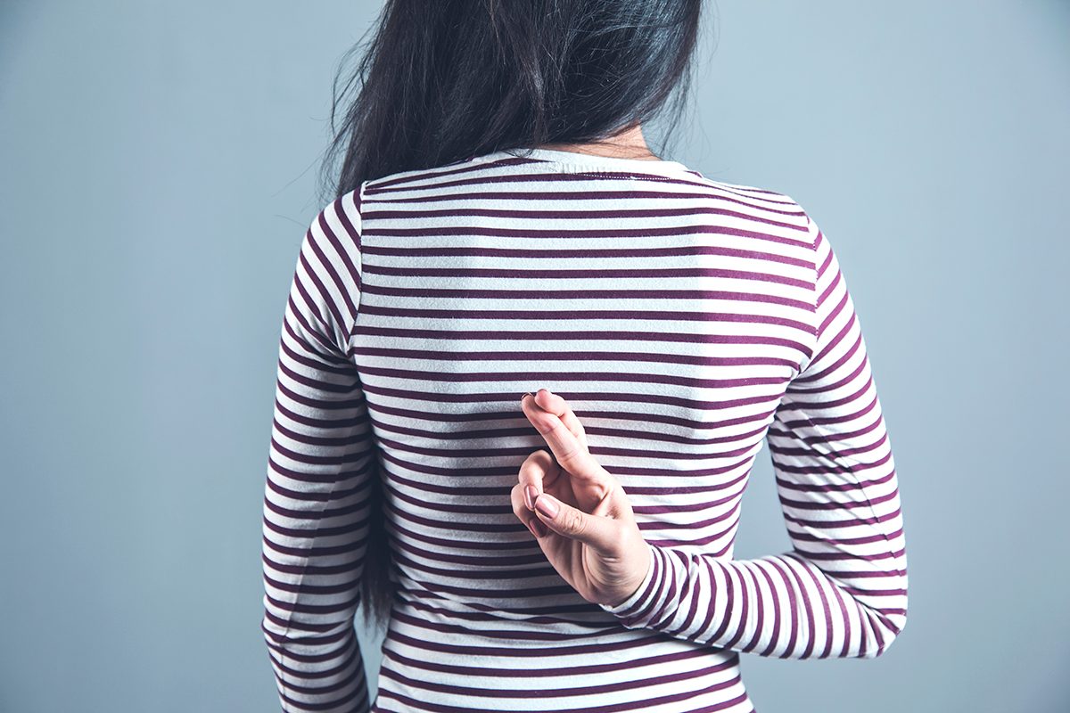 A woman crossing her fingers behind her back