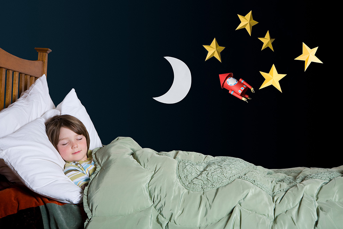 A young boy sleeping in a bed