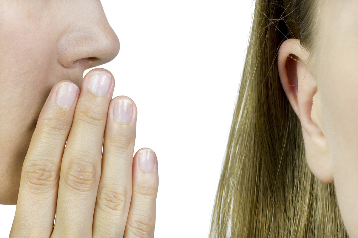 An extreme close-up of someone whispering in a woman's ear