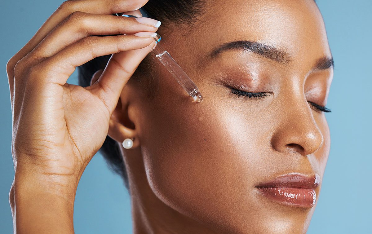 A woman applying serum to her face