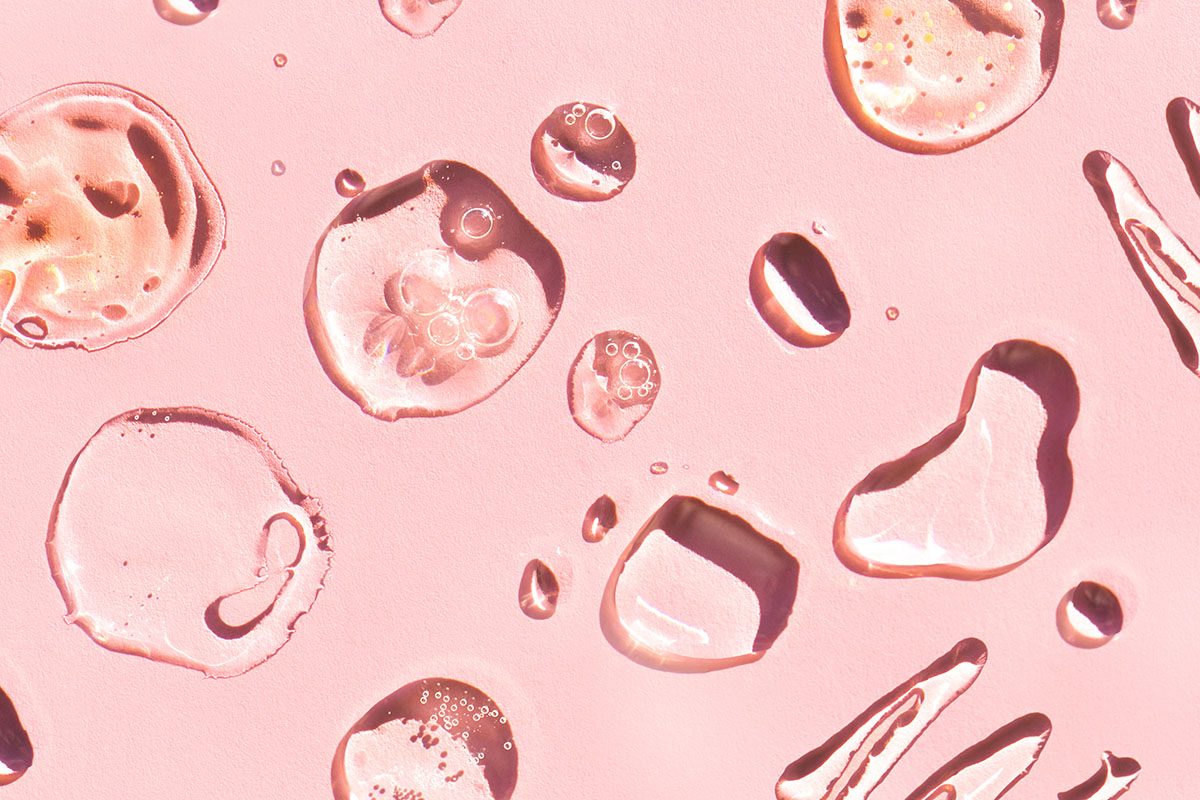Smears of lotions and gels on a pink background