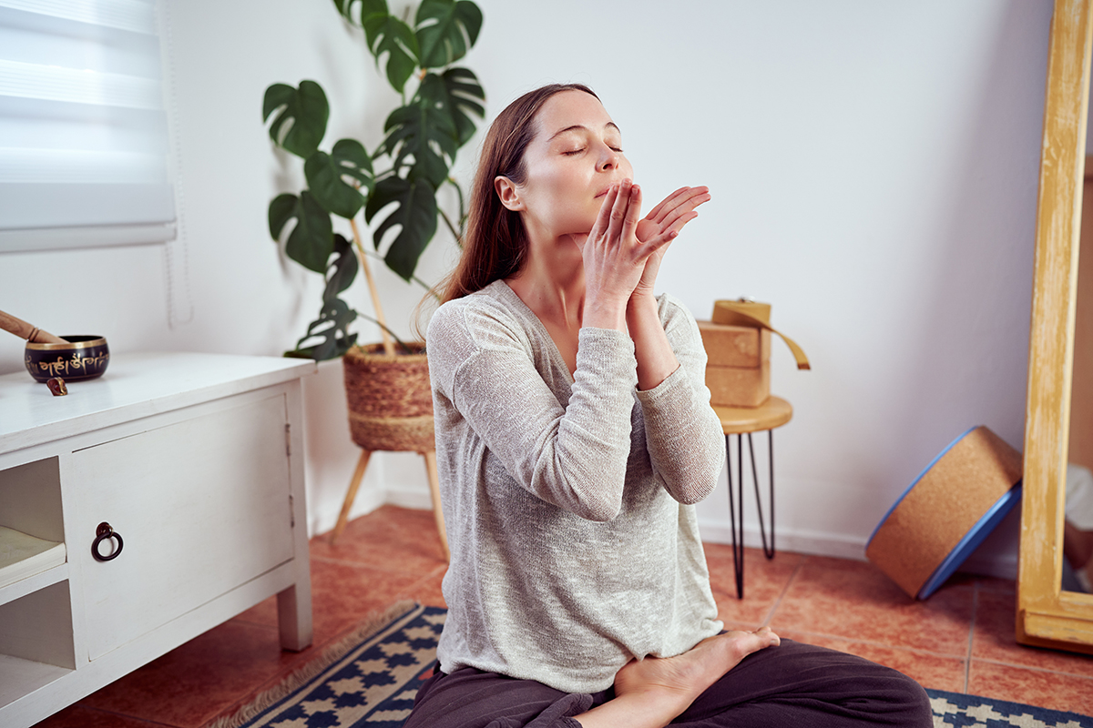 A woman massaging her neck at home