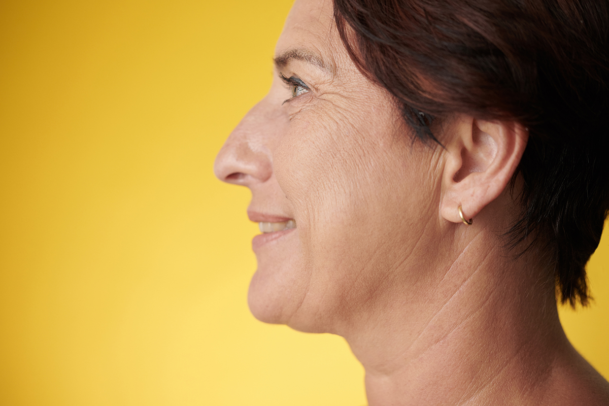 A side profile of a woman against a yellow background