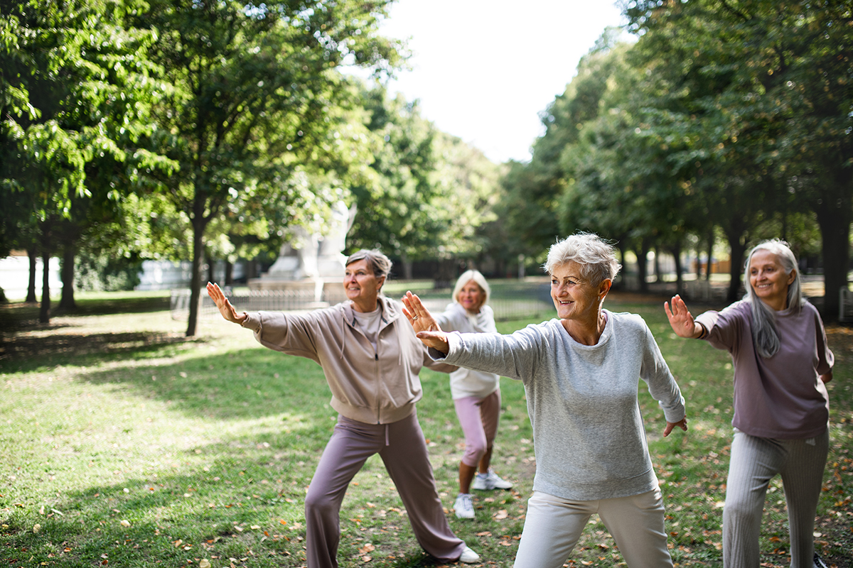 A group of senior women doing tai chi in a park
