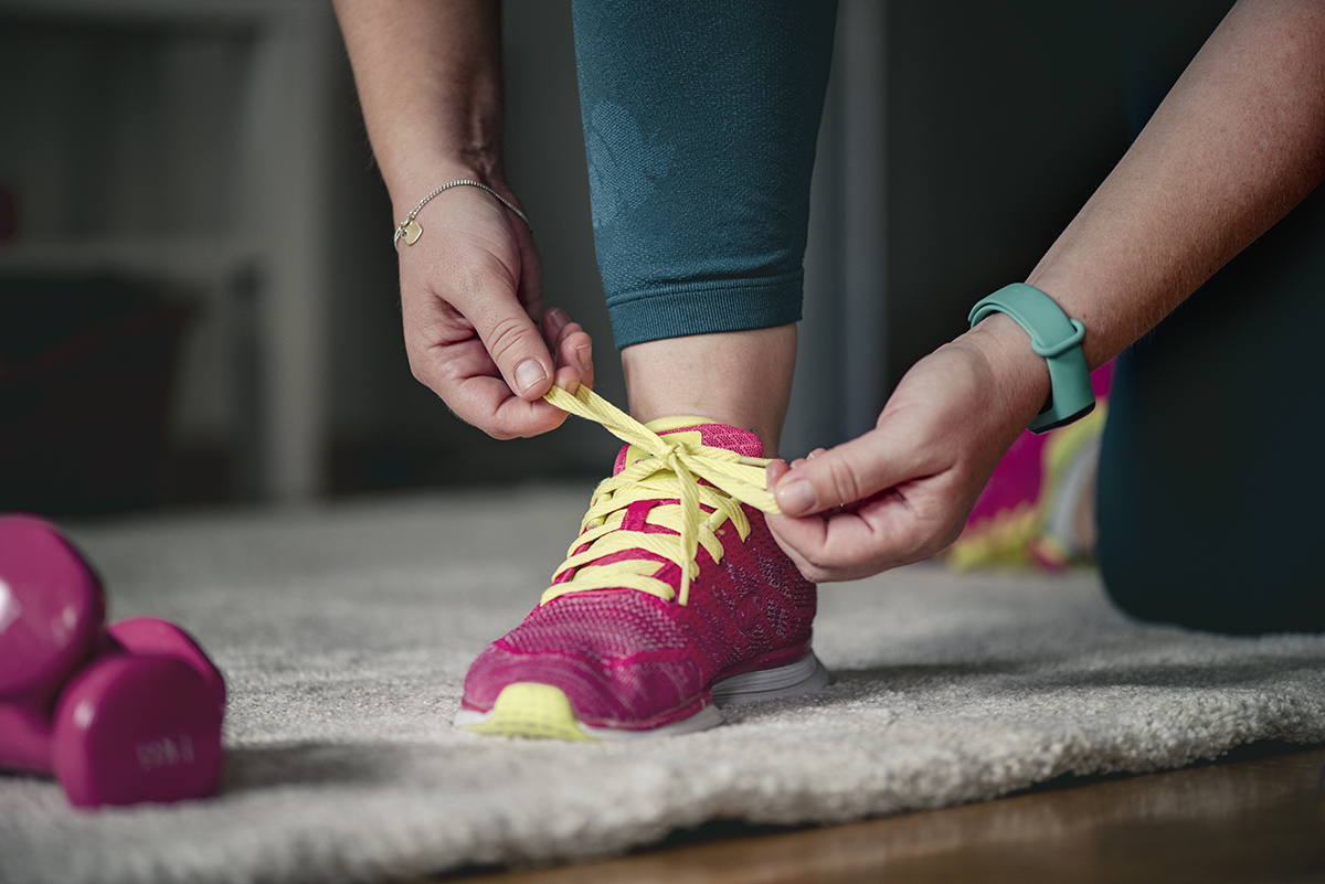 A woman tying up sports trainers