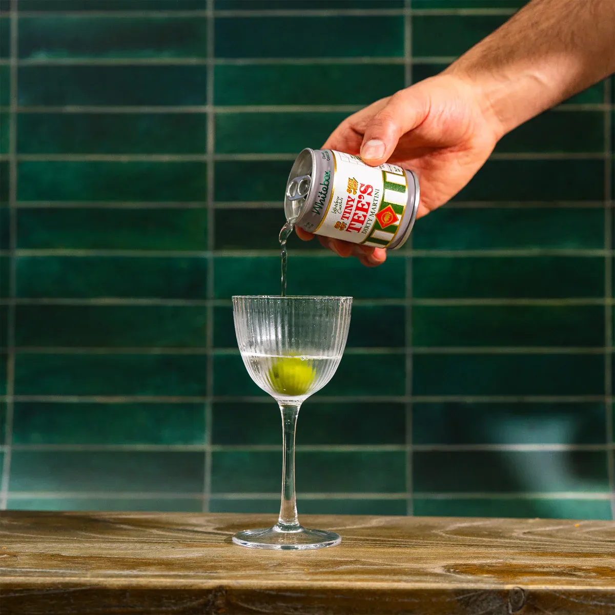 Hand pouring a martini can