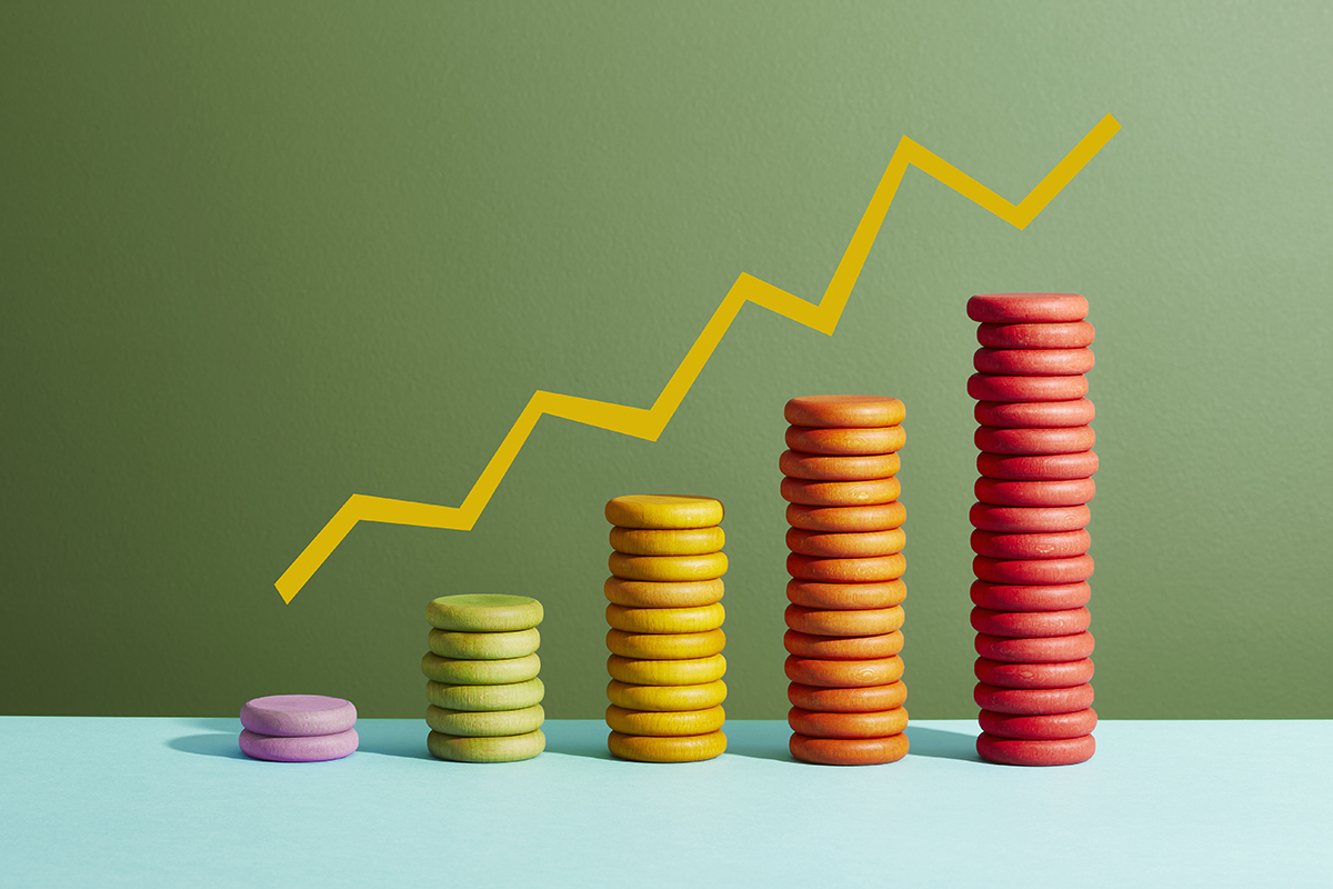 Stacks of colourful coins increasing in height with a graph line above