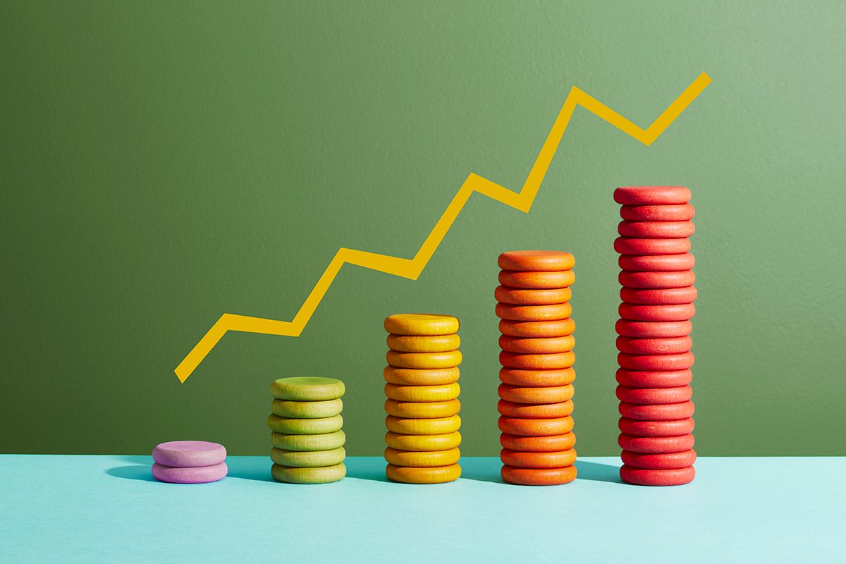 Stacks of colourful coins increasing in height with a graph line above