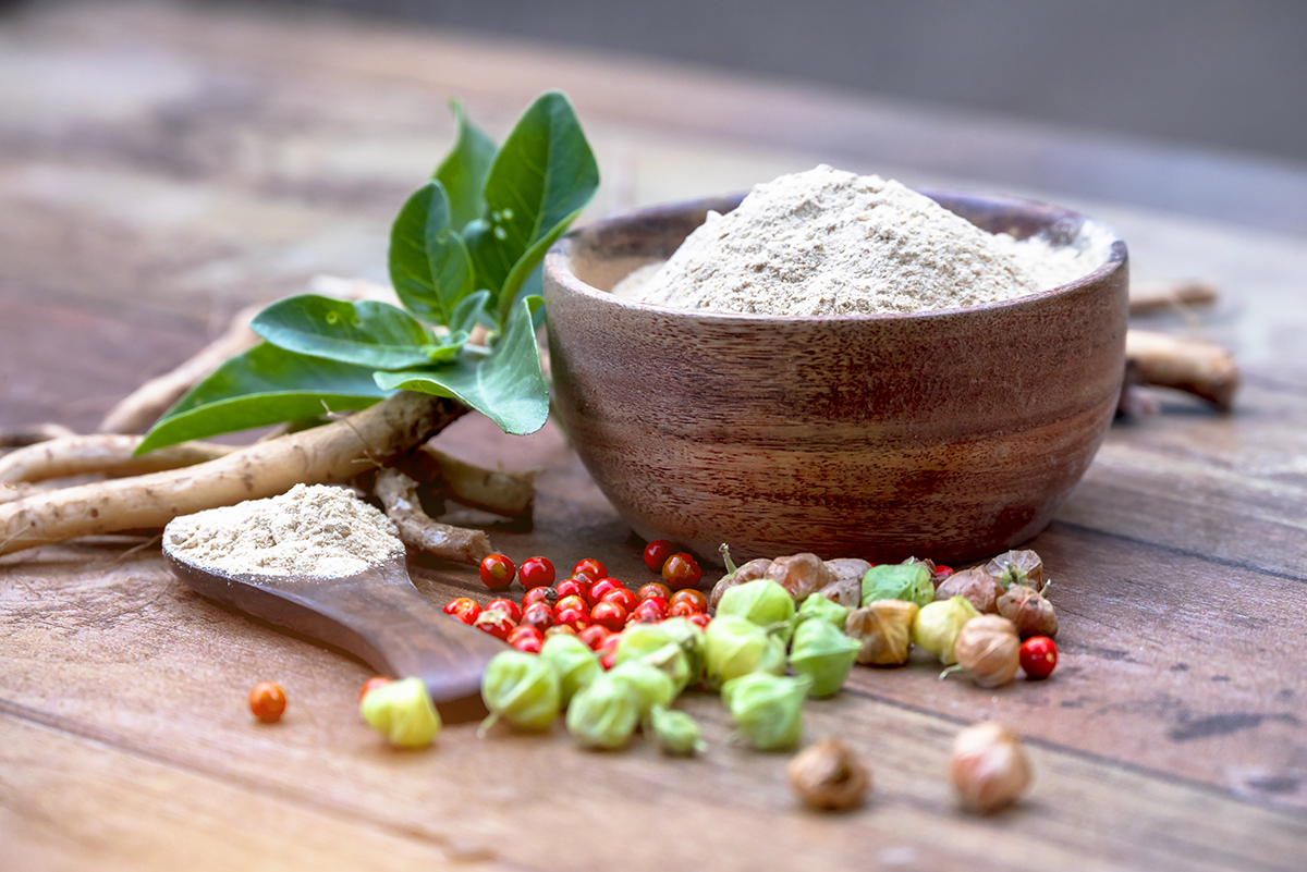 A wooden bowl containing ashwagandha powder