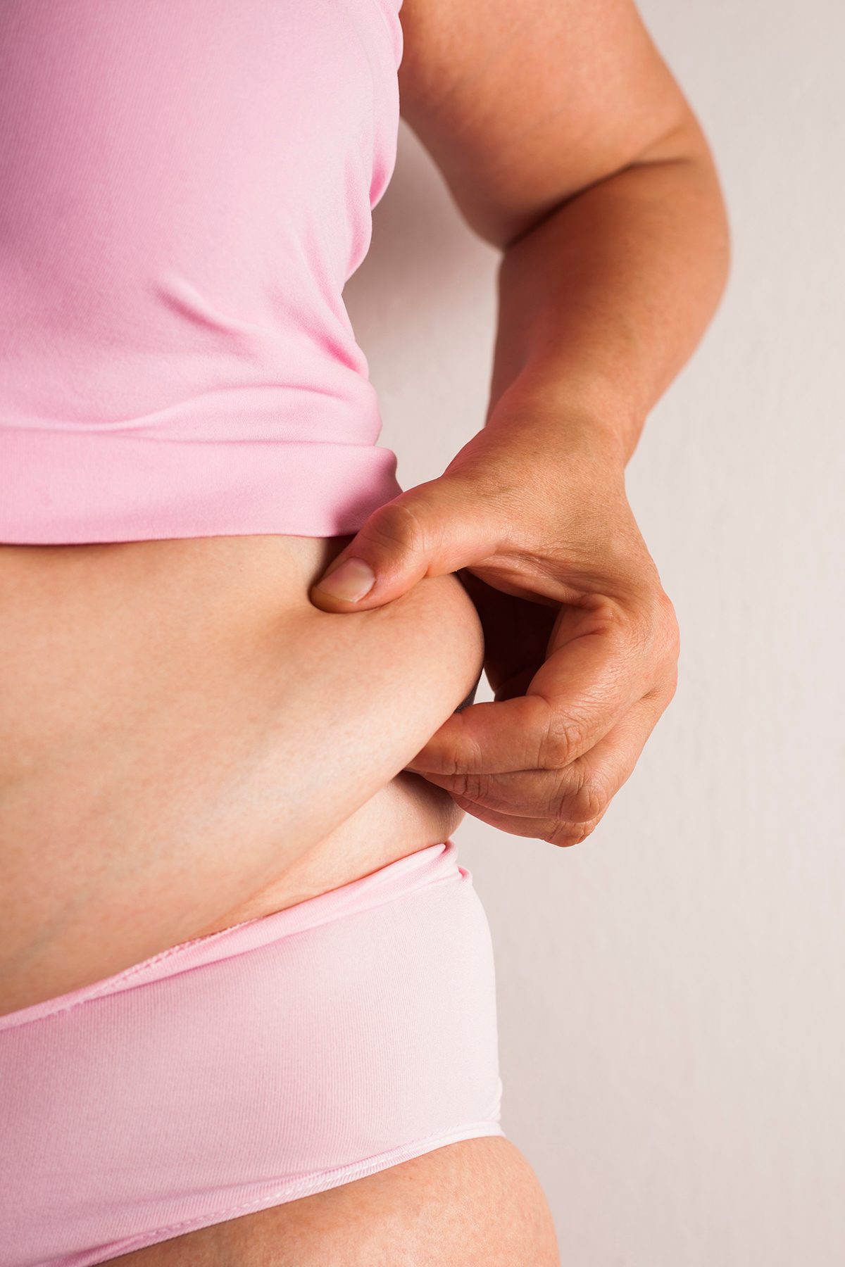 A woman pinching her stomach