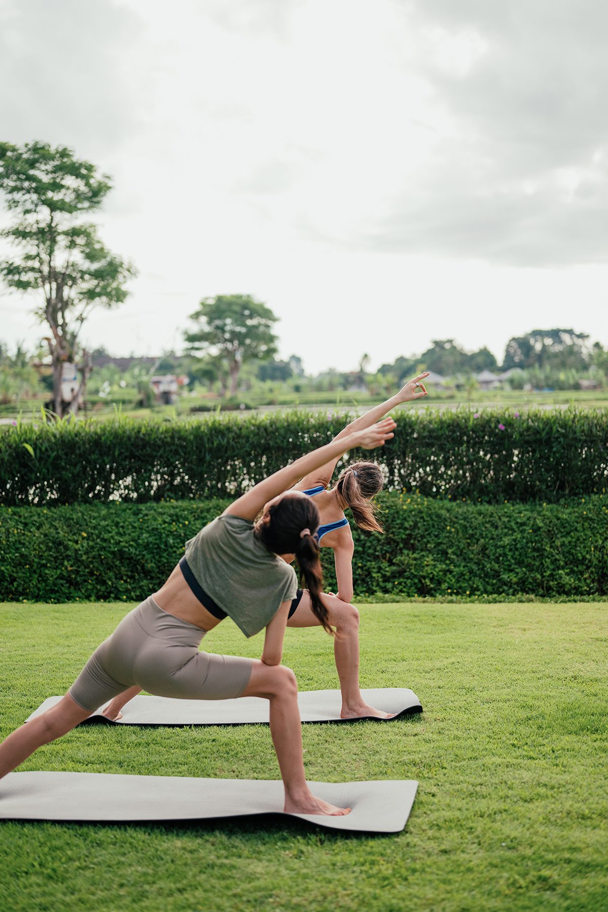 Two women practicing yoga outside