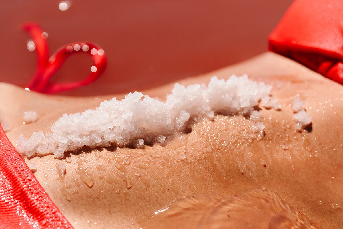 A close-up of a woman's torso covered in salt crystals
