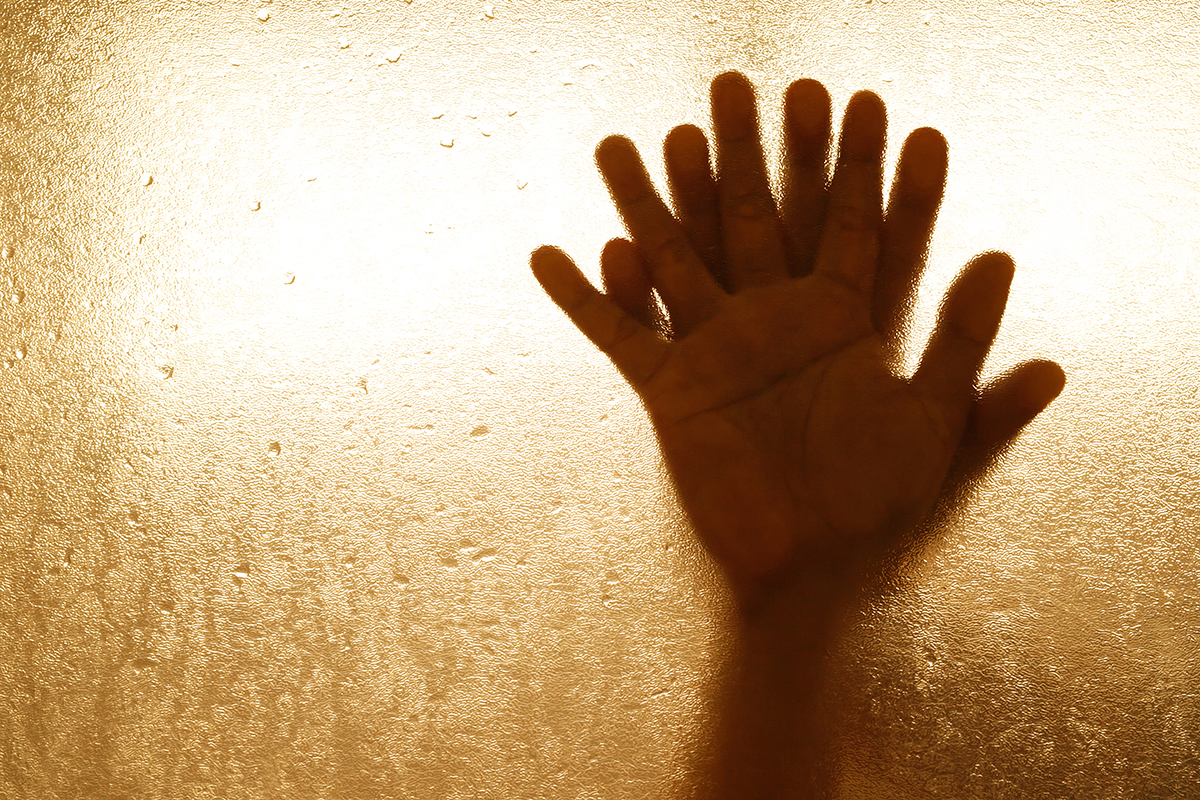 A couple holding hands against steamy glass