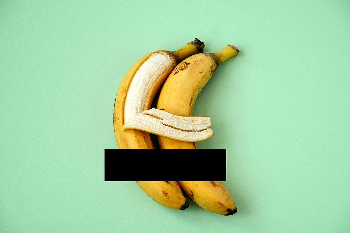 Two bananas on a green background, one appearing to hug the other with its peel