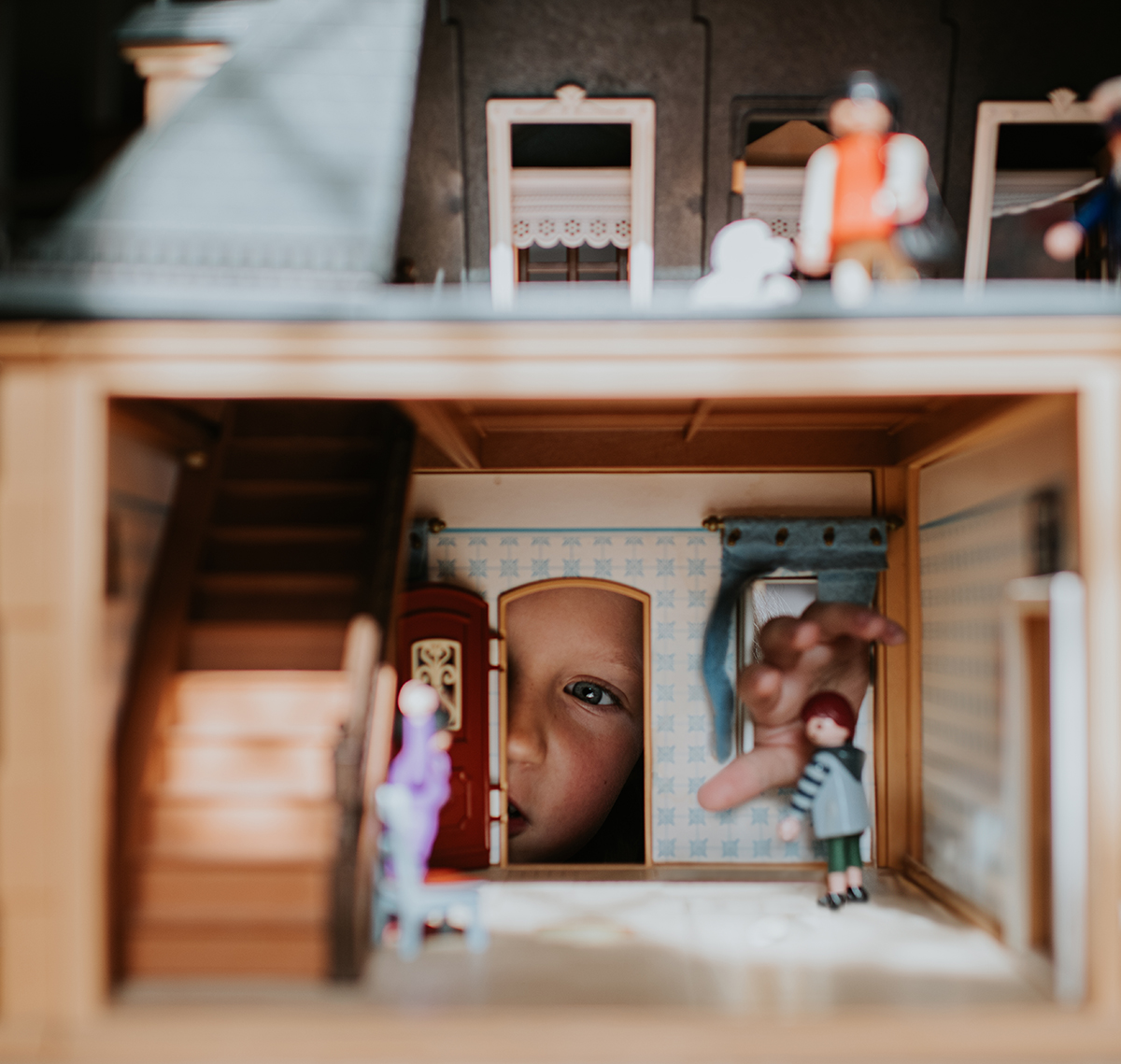 A young girl looking inside a doll's house