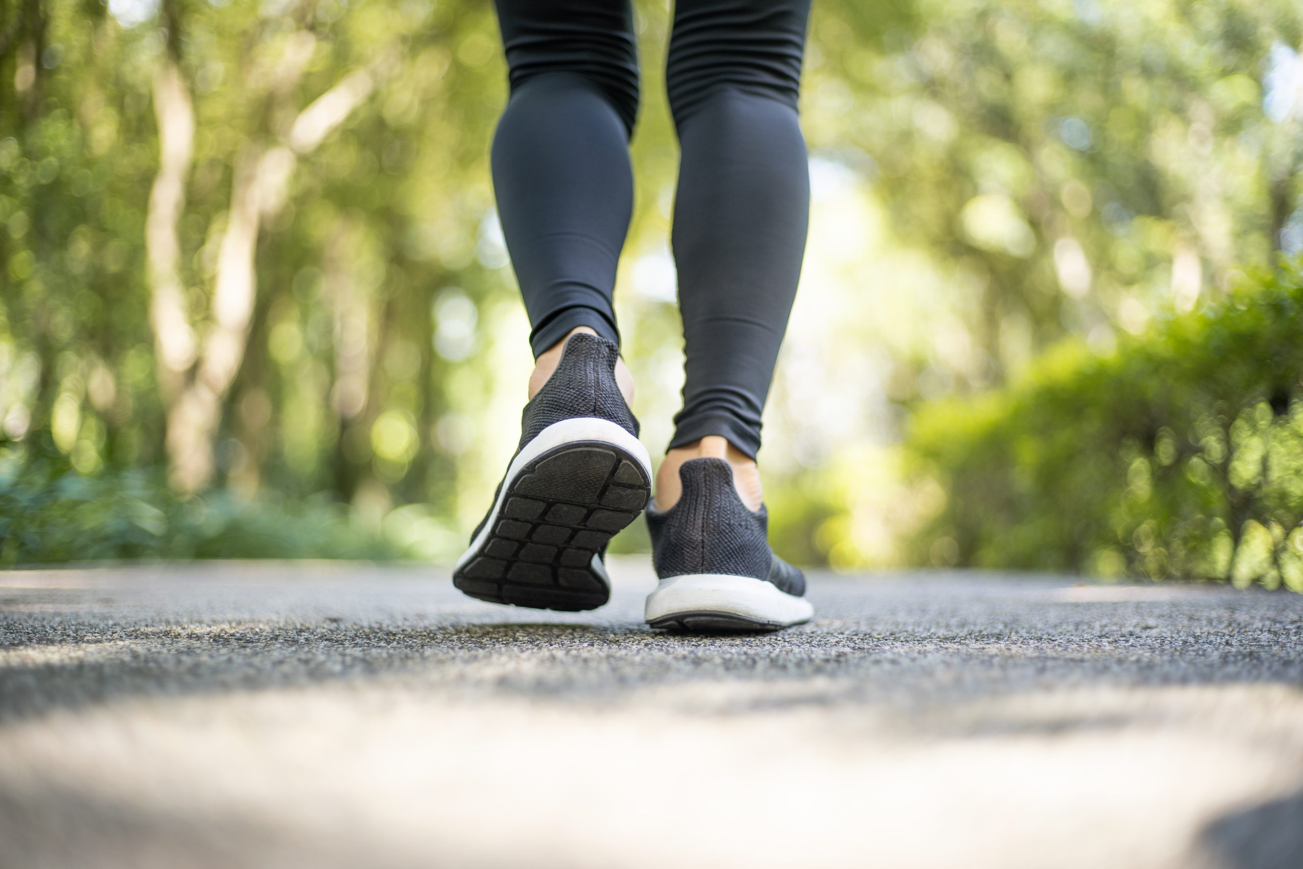 A close-up of a woman jogging outdoors wearing running trainers
