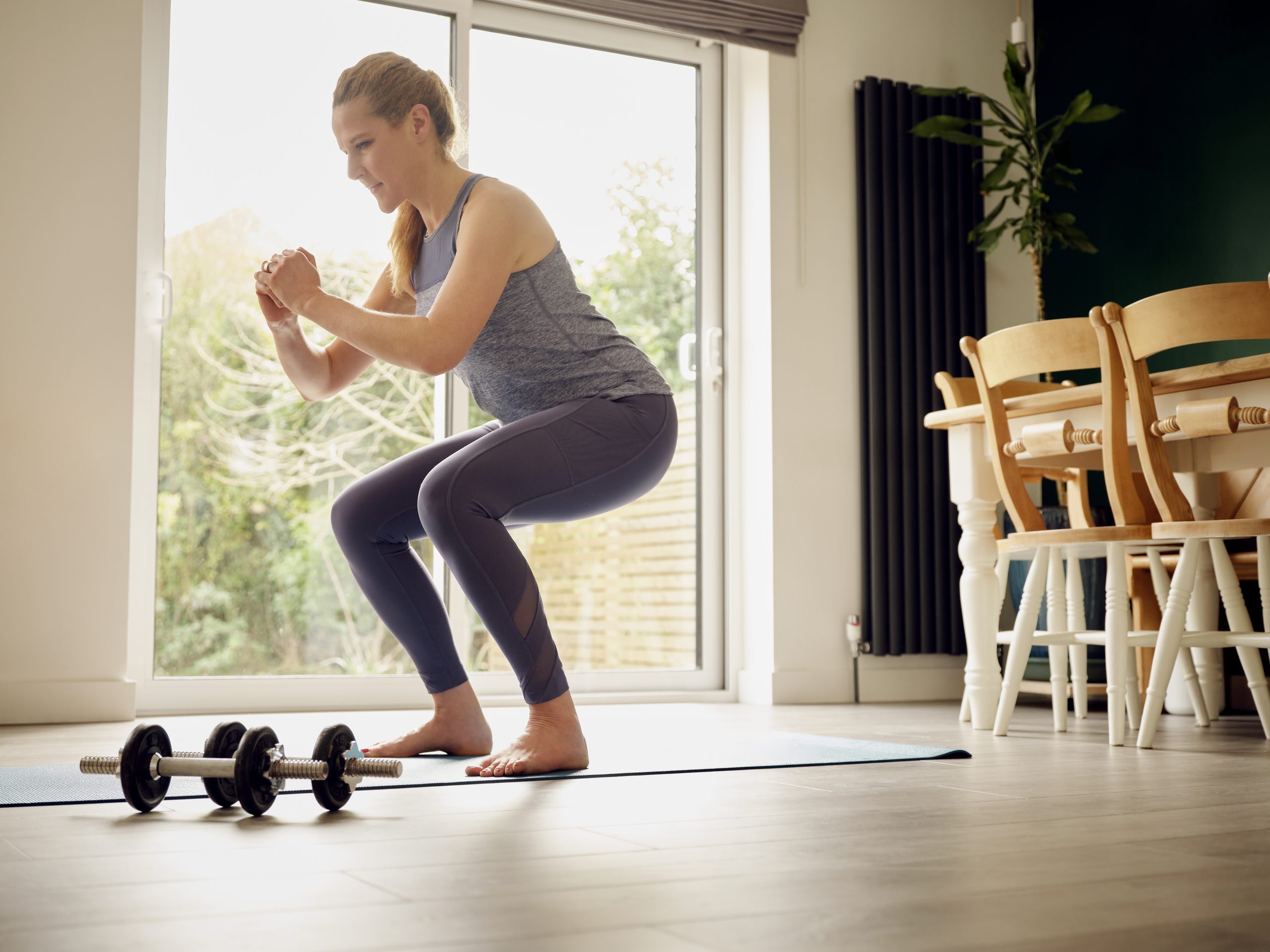 A woman doing squats at home